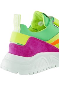 Talons de baskets épaisses en daim vert, jaune, violet, avec des accents orange, une semelle blanche texturée et un col en mesh rembourré.