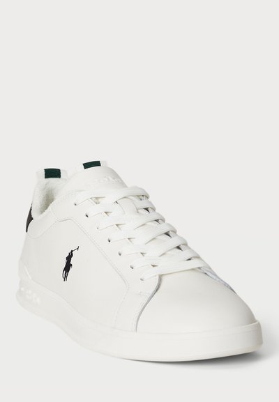 Bijela kožna tenisica s teksturiranom površinom, ravnim vezicama i zelenim naglascima. Ima crni logo sa strane i podstavljenu ovratnik za udobnost.