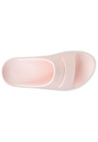 Svetlo roza drsna sandal z gladkim gumijastim materialom, odprtim prstom in dvema stranskima izrezoma za zračnost. Vzorčena podloga za oprijem.
