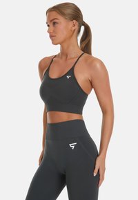 Schwarzer Sport-BH und passende hochtaillierte Leggings, ausgestattet mit einem taillierten Design, glatter Textur und einem weißen Logo-Akzent am Bund.