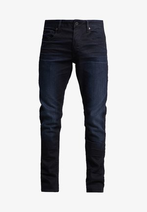 Moške temno modre denimske hlače s slim fit krojem, z gumbom in zadrgo, sprednjimi in zadnjimi žepi, prikazane na beli podlagi.