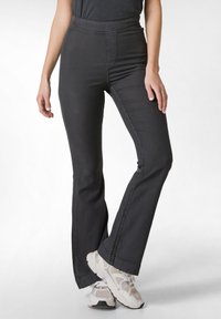 Pantaloni neri a palazzo realizzati in materiale elastico con vita alta; presentano una texture liscia e dettagli di cucitura minimi.