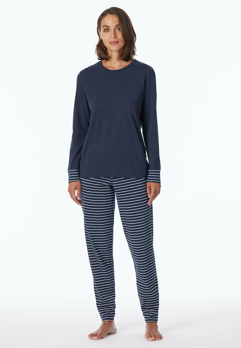 Marinblå långärmad topp med randiga manschetter tillsammans med randiga pyjamasbyxor. Båda i mjukt tyg, vilket ger en avslappnad passform och komfort.