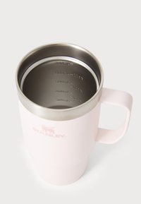 Ροζ ανοξείδωτο ατσάλινο κύπελλο με λεία εξωτερική επιφάνεια, χερούλι και εγχαρακτωμένες ενδείξεις όγκου στο εσωτερικό, με το λογότυπο STANLEY.