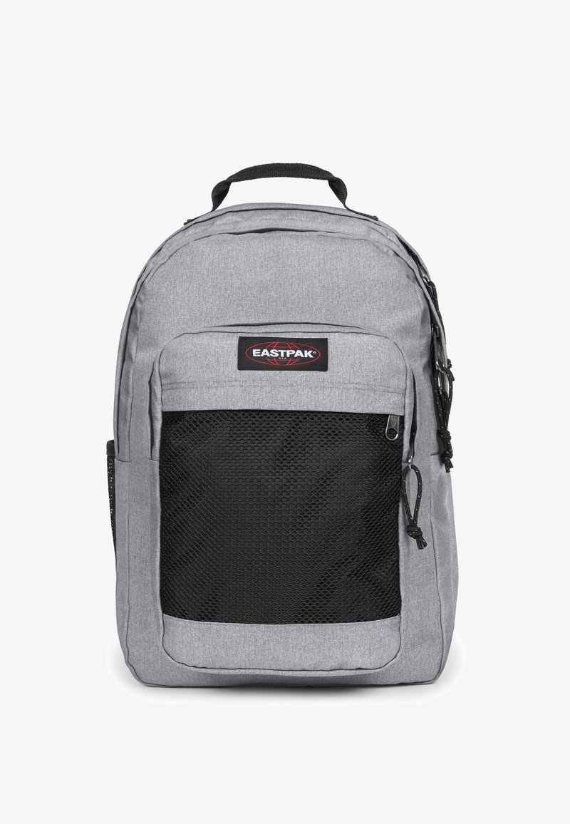 Šedý nylonový batoh s černou síťovanou přední kapsou, horním uchopovačem a nastavitelnými ramenními popruhy. Obsahuje označení značky Eastpak.