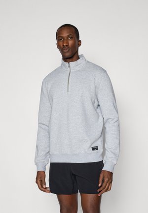 Grauer Reißverschluss-Pullover mit hohem Kragen und gerippten Bündchen, gefertigt aus weichem Stoff, mit einem kleinen Logohangtag am Saum.