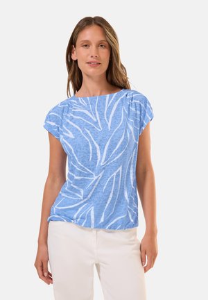T-shirt azzurro chiaro a maniche corte con motivo di foglie bianche e scollo rotondo, realizzato in tessuto morbido e testurizzato, abbinato a pantaloni bianchi.