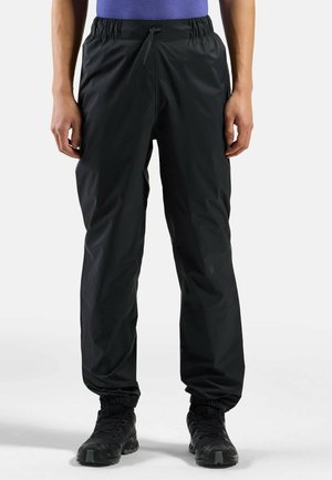 Pantalons étanches noirs avec une taille élastique et un cordon de serrage ajustable. Caractéristiques : poignets élastiques et texture lisse et brillante.