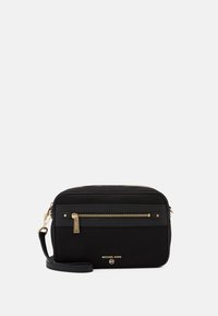 Schwarze Nylon-Crossbody-Tasche mit goldfarbener Reißverschluss- und Hardware. Verfügt über eine vordere Reißverschlusstasche und einen abnehmbaren Trageriemen. Flaggenlogo sichtbar.