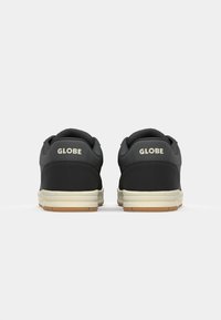 Black sneakers with white accents, featuring a rubber sole and soft padded collar. "GLOBE" logo embossed on the heel section.