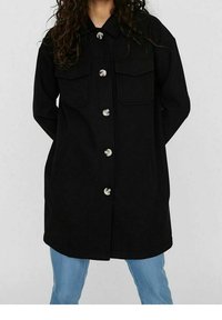 Chaqueta exterior negra con cuello tipo solapa, cierres de botones plateados, dos bolsillos en el pecho y un corte recto. La textura parece suave y gruesa.