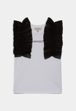 Chemisier blanc sans manches avec des volants froncés en tulle noir sur les épaules et "TWINSET" imprimé sur la poitrine.