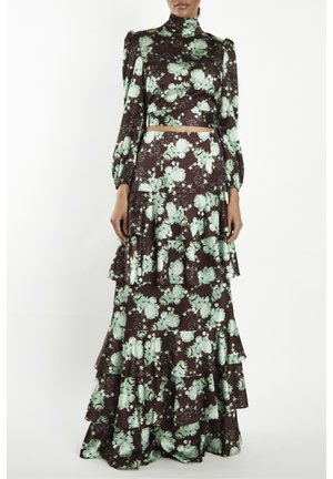 Bloemmotief tweedelig outfit met een hoge hals cropped top en een gelaagde rok. Het materiaal is donkerbruin met groene bloemenpatronen.
