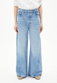 Hellblaue, weit geschnittene Jeans aus Denim mit hoher Taille, fünf Taschen, Knopfverschluss und dezenten Ausbleichungen im Stoff.