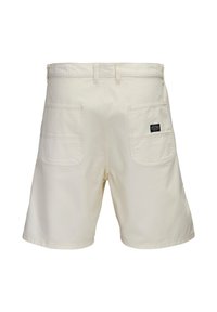 Κρεμ χρώματος casual σορτς με δύο πίσω τσέπες τύπου φόρμας, θηλιές για ζώνη και μια μικρή μαύρη ετικέτα στη δεξιά τσέπη.