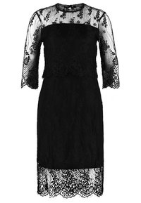 Robe noire longueur genou avec superposition en dentelle florale, manches en dentelle transparente et ourlet festonné.