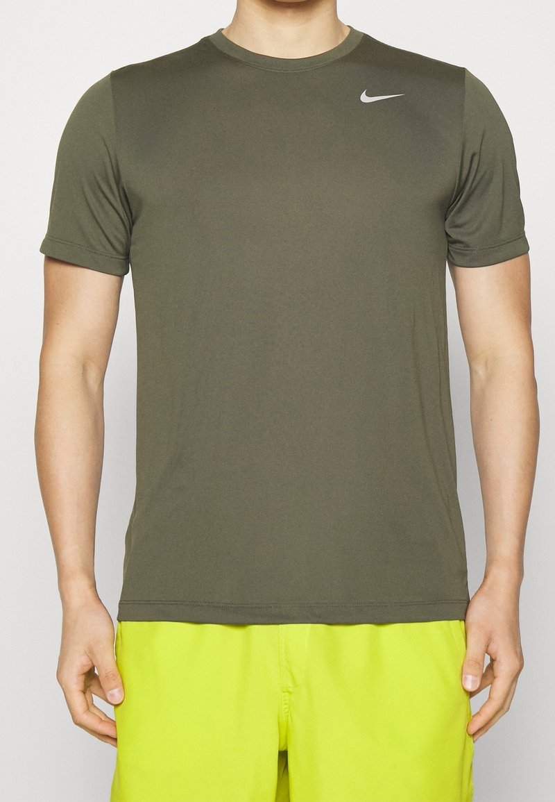 T-shirt sportivo Nike di colore verde oliva, maniche corte, texture liscia, scollatura a girocollo, con un piccolo logo bianco sulla spalla sinistra.