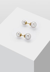 Perl-Ohrstecker mit zwei kugelförmigen, weißen Perlen, montiert auf einem goldfarbigen Metallstift mit einer glatten, polierten Oberfläche.