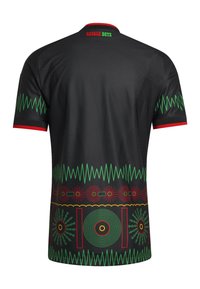 Maglietta nera a maniche corte con bordi rossi, motivi a onde sonore verdi, disegni grafici circolari e la scritta "REGGAE BOYZ" sul collo posteriore superiore.