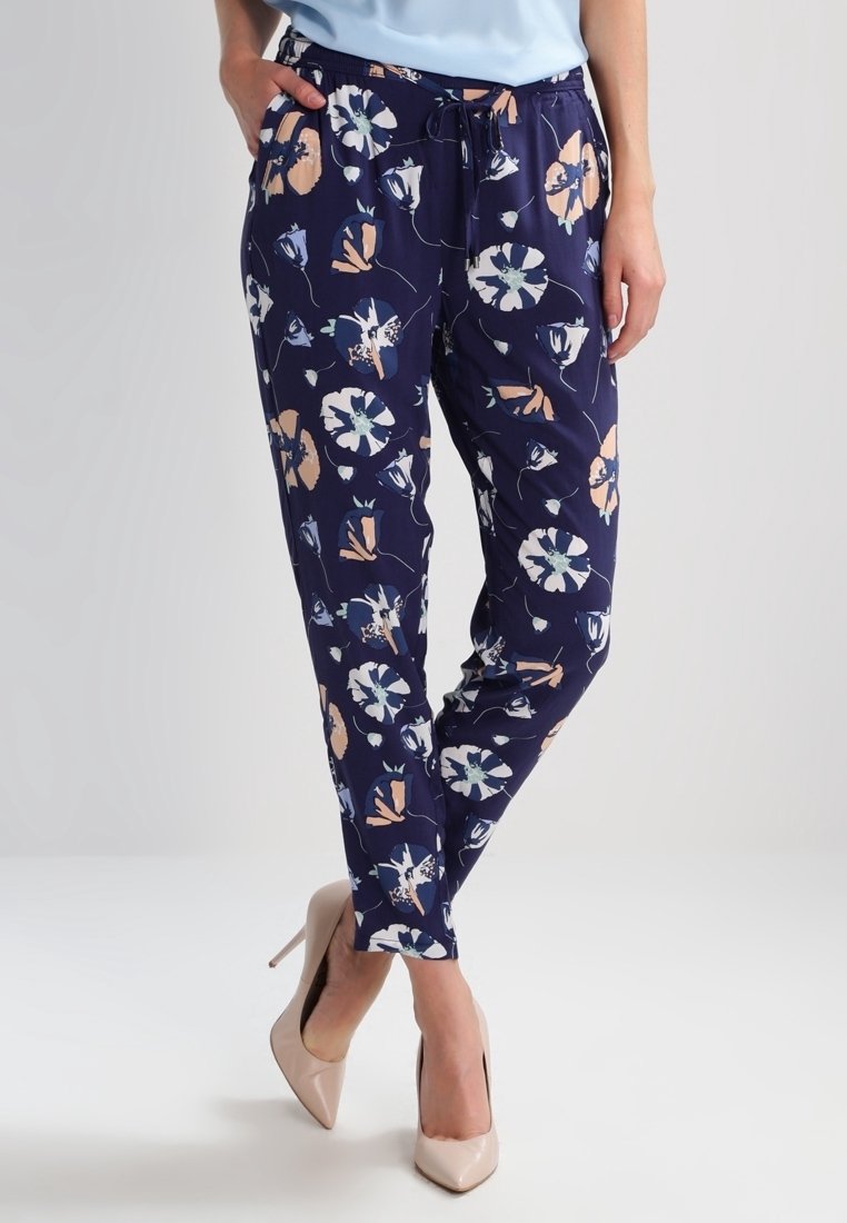 Tmavě modré květinové kalhoty s elastickým pasem a šňůrkou, s bílými, růžovými a modrými akcenty. Hladká textura látky.