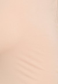 Tecido pêssego claro, textura suave, superfície lisa, ligeiramente elástico, sem padrões ou enfeites visíveis, adequado para vestuário casual.