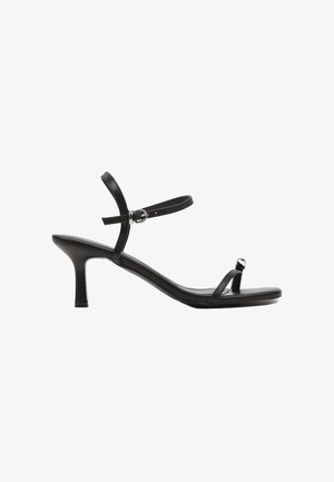 Sandales noires à talons avec un design à lanières, fine bride de cheville et bout carré. Fabriquées en cuir lisse avec une finition brillante.