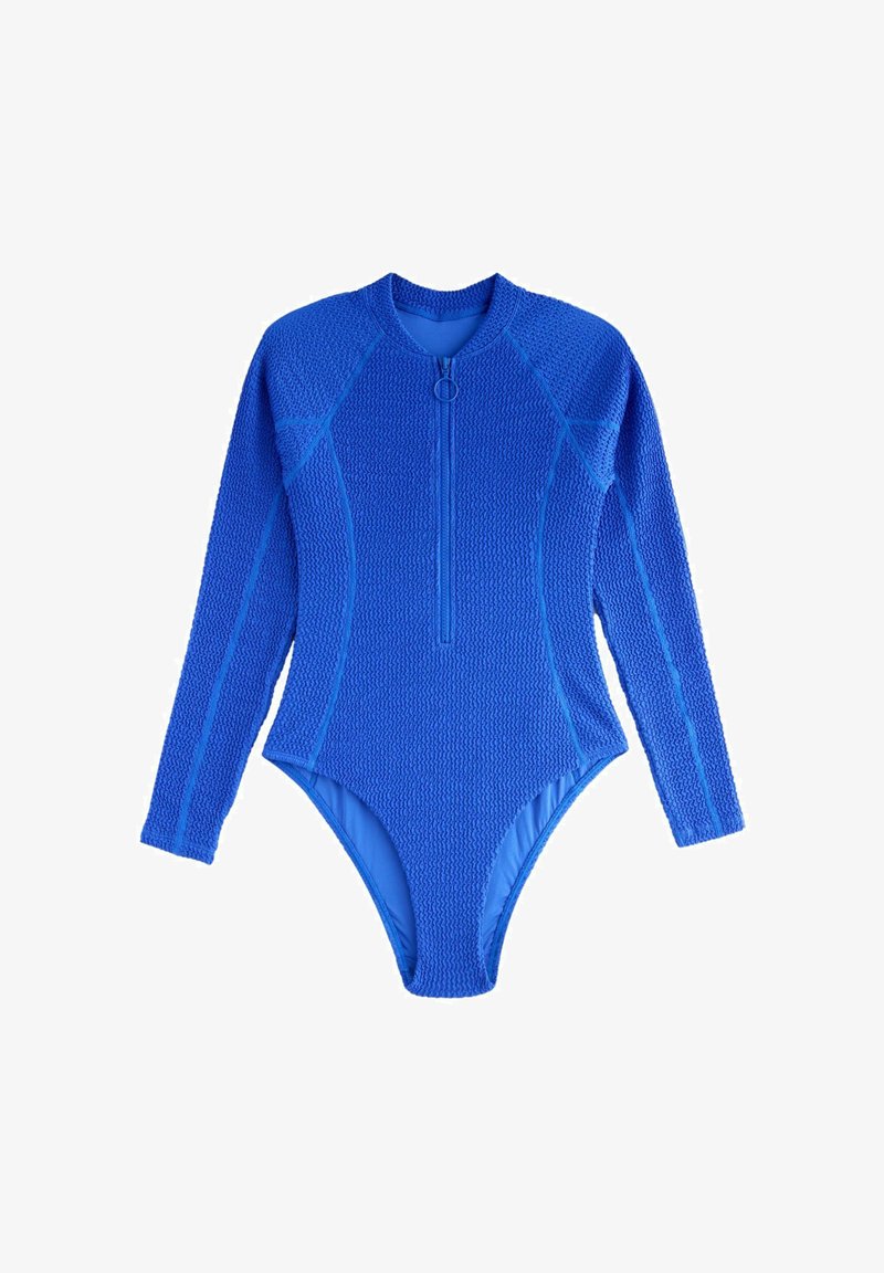 Ilgas rankovėmis mėlynas maudymosi kostiumėlis su tekstūruota paviršiaus struktūra. Turi priekinį užtrauktuką ir aptemptą dizainą su kontrastingomis mėlynomis siūlėmis.