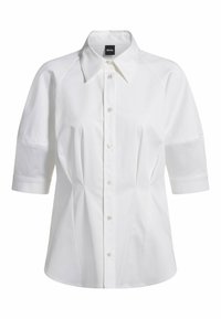 Camicia bianca a maniche corte con colletto a punta, chiusura con bottoni e cuciture strutturate. Il tessuto è liscio con una leggera lucentezza.