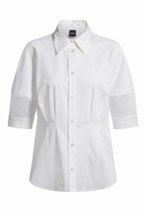 White short-sleeve shirt with a pointed collar, button front, and structured seams. Fabric is smooth with a slight sheen.