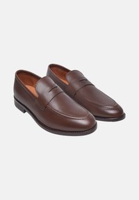 Braune Leder-Loafer mit glattem Finish, abgerundeter Spitze und K stitching-Details. Synthetische Sohle mit niedrigem Absatz und minimalistischem Design.