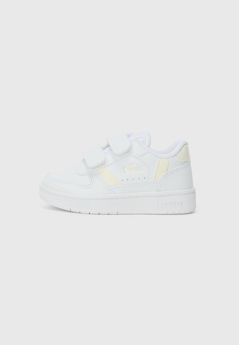 Valged tennisajad, millel on siledast nahast ülemine osa, Velcro rihmad, kollased aktsendid külgedel ja tekstureeritud kummiala.