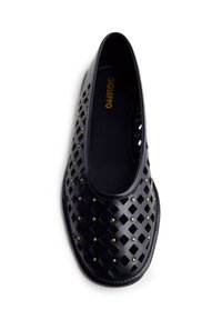 Zapato de cuero negro con un patrón de diamantes cortados y tachuelas en tono dorado. Punta redondeada y forro interior suave. Diseño de suela plana.