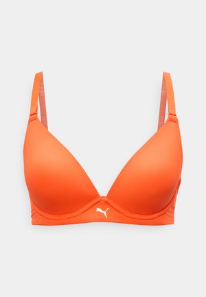 Πορτοκαλί ενισχυμένο σουτιέν με ρυθμιζόμενους ιμάντες και λευκό λογότυπο Puma στο κέντρο κάτω από τα κυπελλάκια, σε απλό γκρι φόντο.