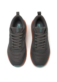 Zapatillas deportivas grises con una parte superior de malla transpirable, cordones y una suela texturada. Presenta una entresuela naranja y un acento azul verdoso en el talón.