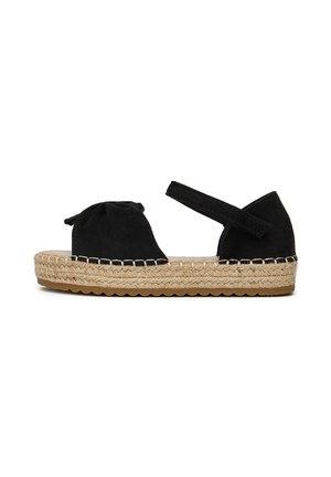 Sandali espadrilles in suede nero con una parte anteriore annodata e cinturino alla caviglia. Suola in juta intrecciata con fondo in gomma. Design con punta arrotondata.