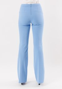 Pantaloni a palazzo azzurro chiaro, a vita alta, con una superficie liscia, chiusura con zip sul retro e due tasche posteriori, progettati per una silhouette aderente.