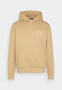 Felpa con cappuccio beige, dotata di tasca frontale, polsini a coste e piccolo logo ricamato "CK" bianco sul petto. Tessuto morbido.