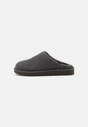 Chausson en daim gris foncé à enfiler avec semelle épaisse en caoutchouc et doublure en polaire douce, conçu pour le confort à l'intérieur.