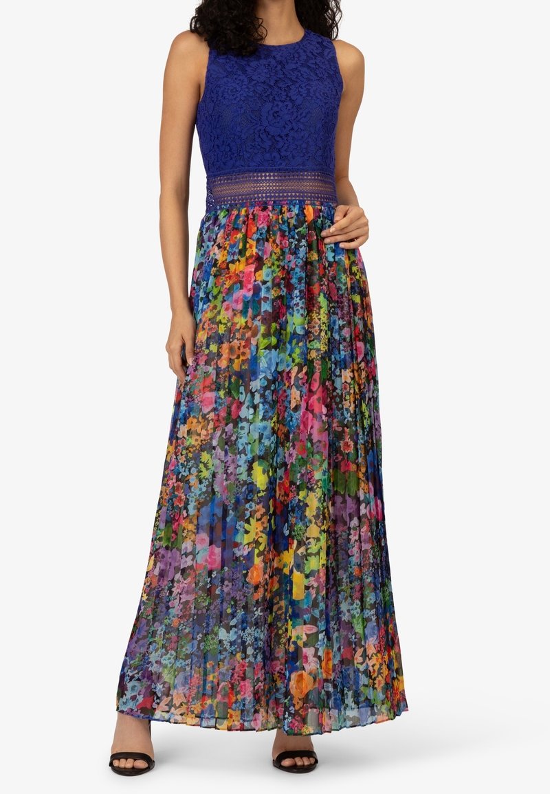 Maxi-jurk met een blauwe kanten top en een kleurrijke, geplooide rok met bloemen. Heeft een getailleerde taille en open patroonaccenten.