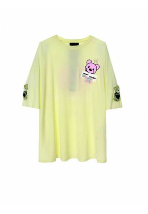 Camiseta amarilla de gran tamaño con cuello redondo, mangas cortas, gráficos de osos en la parte delantera y parches decorativos en las mangas.