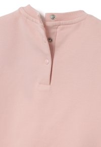 Sudadera rosa con cuello acanalado, botones a presión y una suave tela texturizada. El diseño incluye una tapeta con dos botones.
