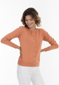 Cardigan leggero a maniche lunghe di colore corallo arancione. Presenta un colletto rotondo e chiusura frontale con bottoni. Texture liscia con polsini aderenti.