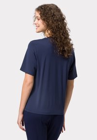 Námořnické tričko s krátkým rukávem vyrobené z měkké tkaniny, s kulatým výstřihem a volným střihem. Zadní pohled ukazuje hladkou texturu a jednoduchý design.