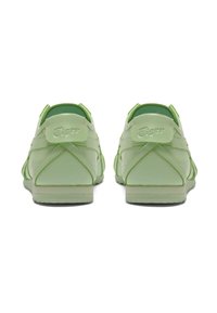 Zelené tenisky s hladkým syntetickým materiálem, zaobleným tvarem, polstrovaným jazykem a logem na patě. Podešev z gumy s vzorkem pro lepší přilnavost.