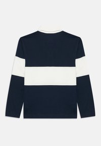 Ναυτικό πόλο μακρυμάνικο με λευκή οριζόντια ρίγα στη πάνω πλευρά του σώματος. Διαθέτει κλασικό γιακά και πλέ knitted μανσέτες. Μαλακό υλικό.