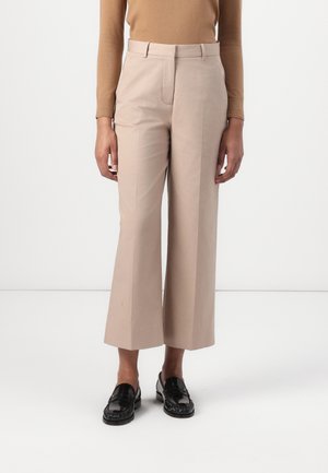 Pantaloni bej, cu pantaloni largi, dintr-un material neted, având buzunare laterale, față plată și o croială ajustată. Purtați cu mocasini negri.