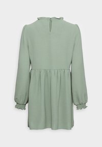 Ljusgrön långärmad klänning med plisserad midja och volangkrage. Har elastiska manschetter och knappstängning med nyckelhål på baksidan.