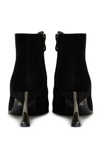 Botines de ante negros con un diseño elegante, que cuentan con tacones metálicos plateados y cremalleras laterales. Textura suave y forma contorneada.