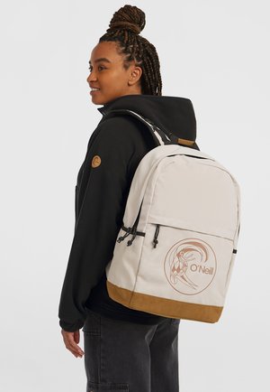 Sac à dos beige avec un fond marron, des accents noirs et un logo O'Neill circulaire. Comprend deux poches latérales et des bretelles réglables.