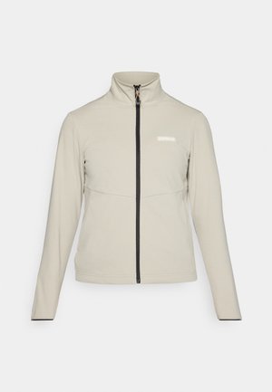 Jasnobeżowa kurtka z wysokim kołnierzem, pełnym zamkiem z przodu i czarnymi szwami. Posiada logo na klatce piersiowej oraz długie rękawy.